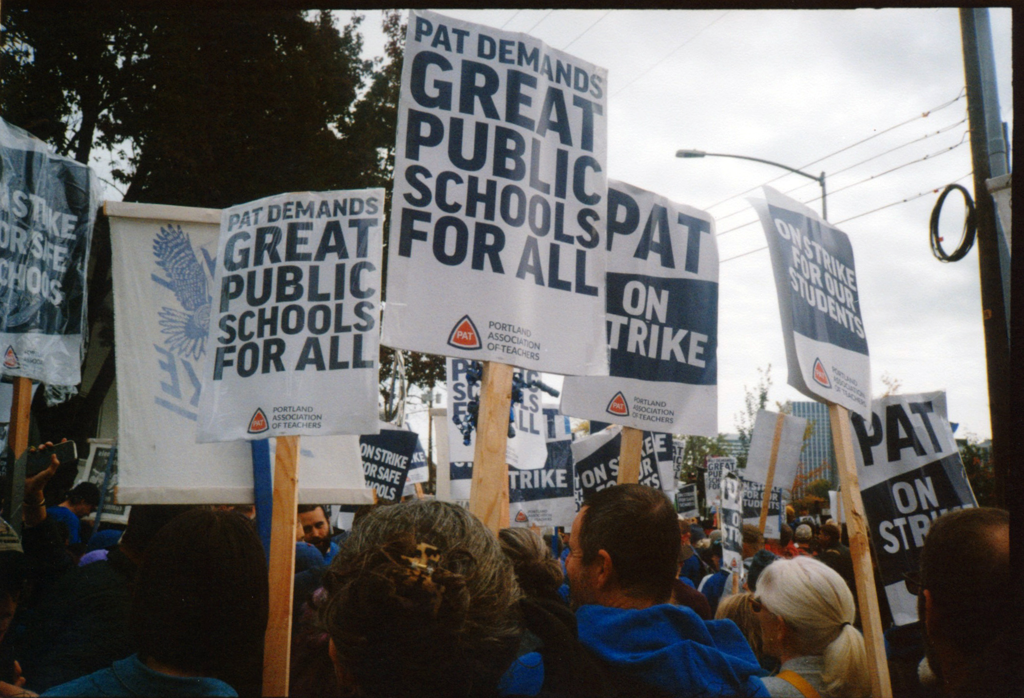 A COLOR PHOTO OF PICKET SIGNS IN A CROWD / PAT DEMANDS GREAT PUBLIC SCHOOLS FOR ALL