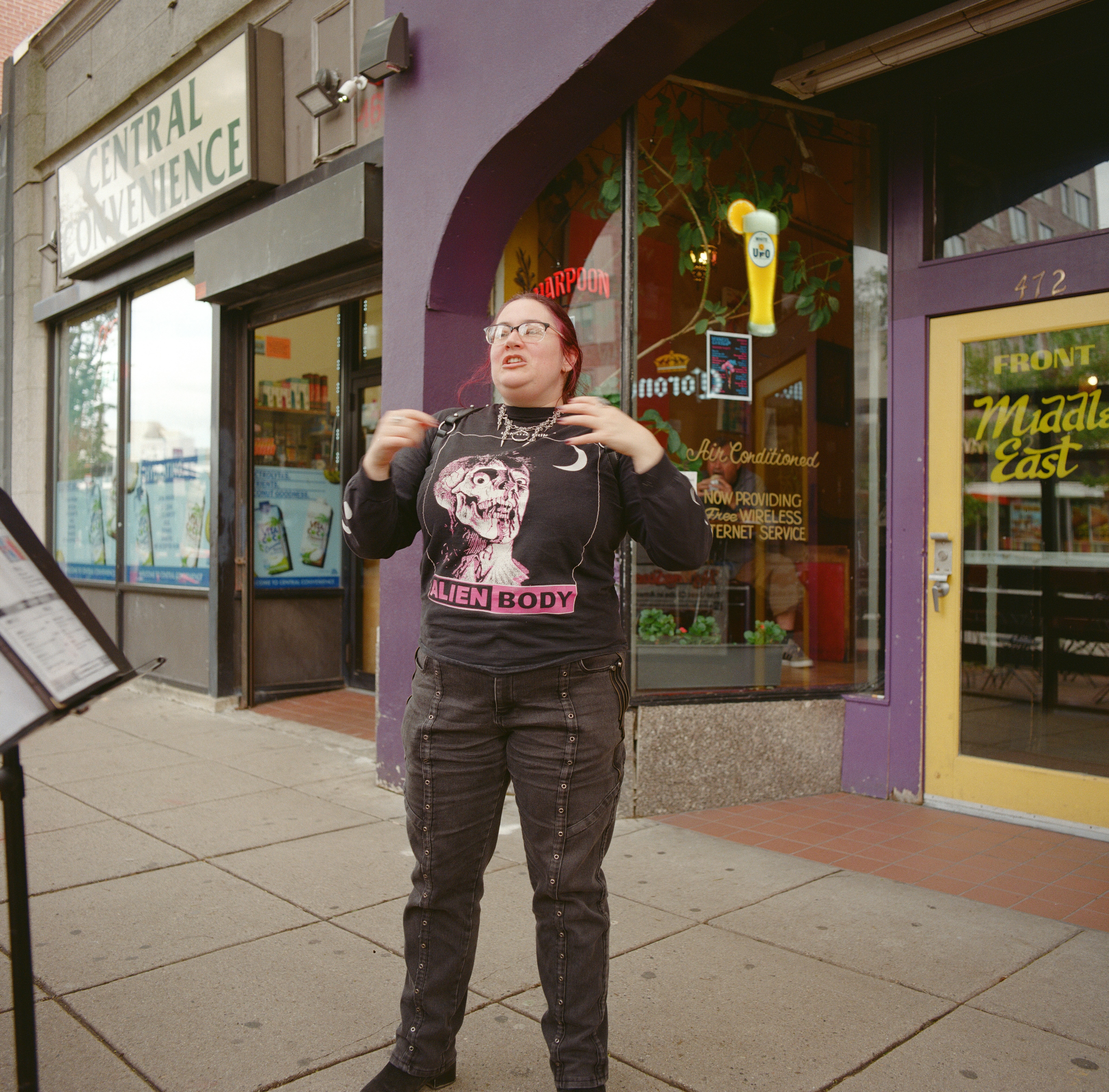 A TOTALLY RAD GOTH ADJACENT PERSON MID STORY IN FRONT OF THE MIDDLE EAST IN CENTRAL SQUARE